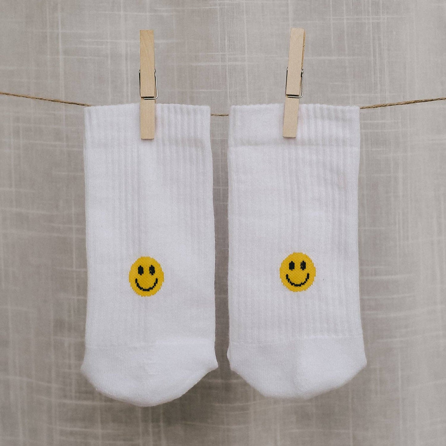 Calcetines blancos con carita sonriente amarilla