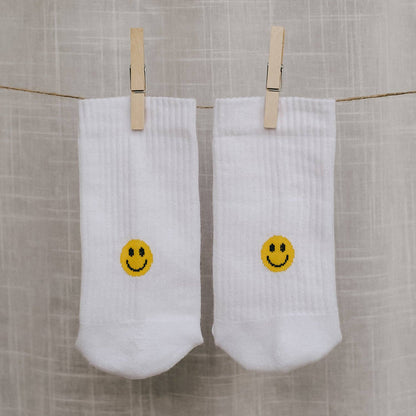 Calcetines blancos con carita sonriente amarilla