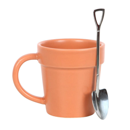 Taza de cerámica con forma de maceta y pequeña cuchara.